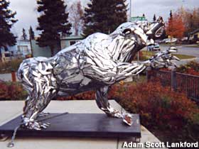 Side view of bear made of chrome car bumpers.