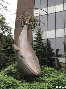 Whale sculpture in front of building.