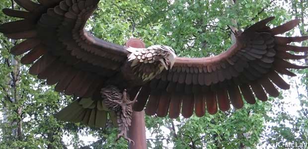 Eagle sculpture with spread wings appears to be swooping down on prey.