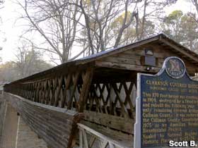 Wooden covered bridge and its historical marker.