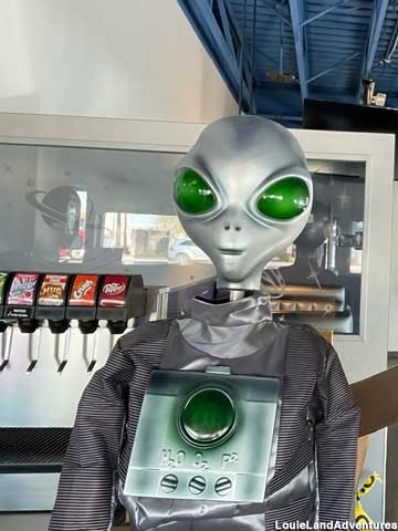 Alien at the soft drink dispenser.