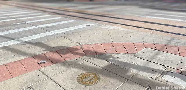 Walkway plaque marks first traffic pedestrian signal.