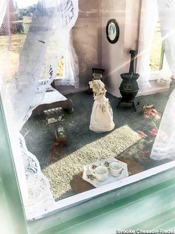 A peek in the window of the dollhouse grave.