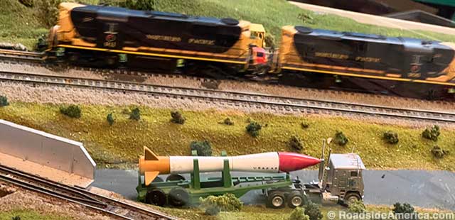 Miniature railroad train passes road-worthy ICBM.