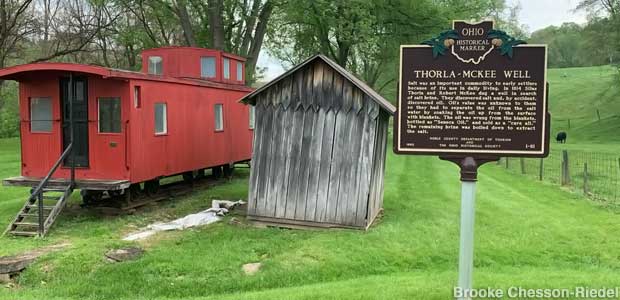 Caboose without wheels, shed, historical marker.