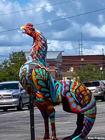 Rooster statue painted in wild colors and designs.