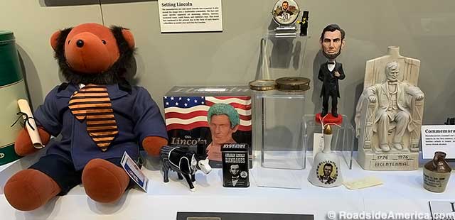 Lincoln bear, cow, Chia Pet, band-aids, bobblehead, bell, and Lincoln Memorial whiskey bottle.