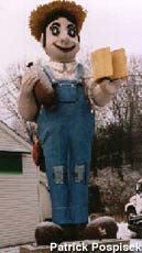Strange Farmer statue holding hot dog and mugs.