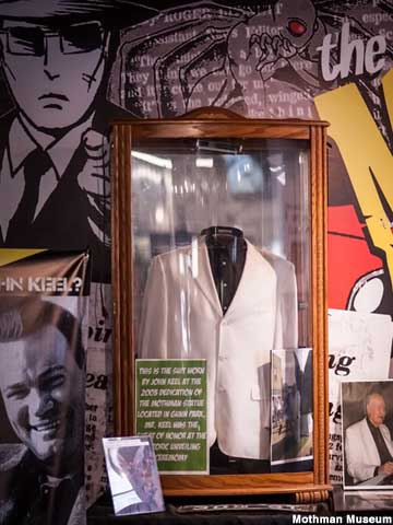 White sport coat in a glass display case.