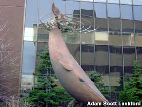 Last Blue Whale sculpture stands in front of building.