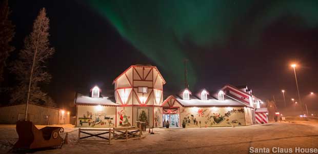 Santa Claus House after dark, with Northern Lights glowing in the sky.