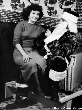 Old photo of Santa in a chair with Mrs. Claus sitting on his lap.