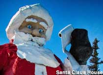 Santa Claus statue stares at Naughty or Nice list in his gloved hand.