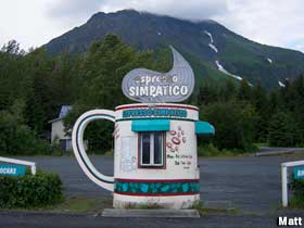 Outdoor coffee stand is a small building shaped like a colorful coffee pot.