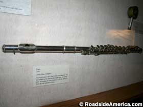 Flute in a wall display case is actually a gun.