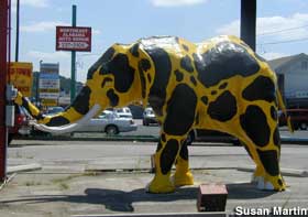 Statue of an elephant painted with yellow and black spots like a leopard.
