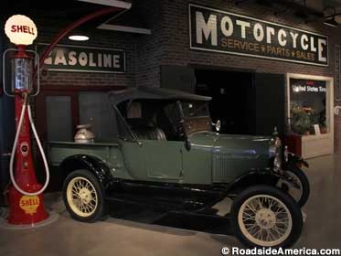 1920s pickup truck parked next to a recreated indoor 1920s gas station.