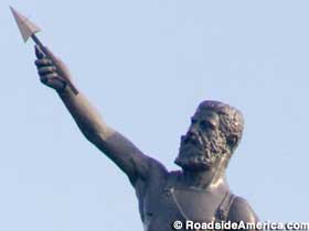 Statue of bearded man holding aloft a spear point.