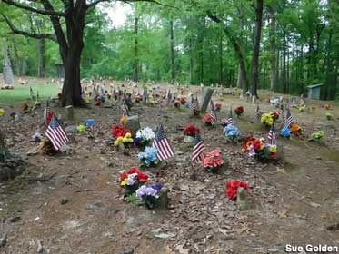 Flowers and small American flags mark many graves in the Coon Dog Cemetery.