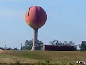 Water tower with globe top painted to resemble a peach.