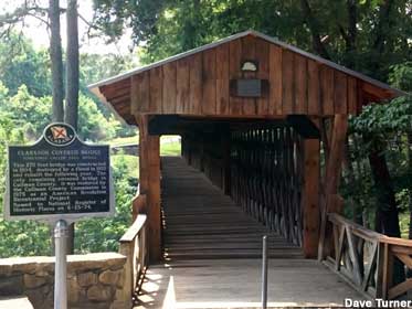 Entrance to wooden covered bridge and its historical marker.