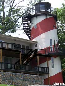 Squat, candy-striped lighthouse attached to a normal-looking home.
