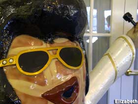 Large outdoor upright fiberglass peanut painted to resemble Elvis Presley.