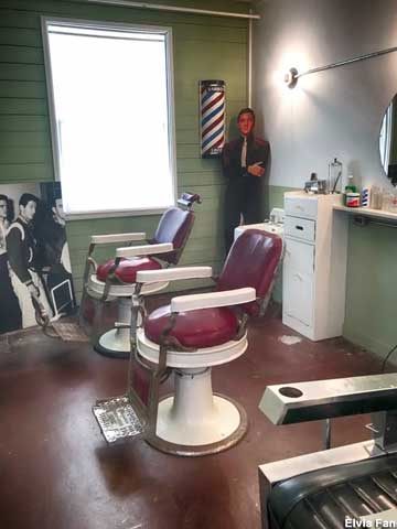 Elvis cardboard cutout observes Army barbershop visitors.
