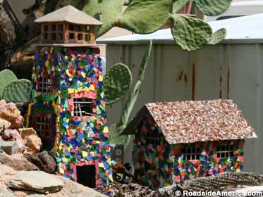 Miniature buildings covered with dinnerware shards and color ceramics.