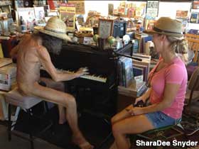 Naked bookstore owner plays the piano.