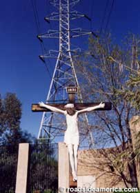 Jesus crucified below the local power grid.