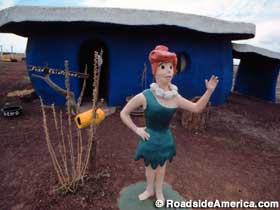 Wilma statue in front of one of the Bedrock City stone houses.