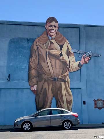 Mural of Charles Lindbergh holding a tiny Spirit of St. Louis.