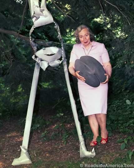 Elizabeth Tashjian with yard sculpture and giant nut, 1985