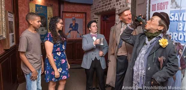 Live tourists contemplate wax dummy drunks at the Prohibition Museum.