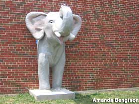 Elephant extrudes from brick wall.