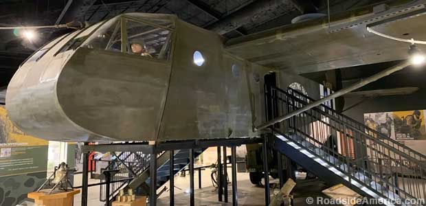 Indoor display of a fabric-covered World War II glider, the same type that landed troops on D-Day.