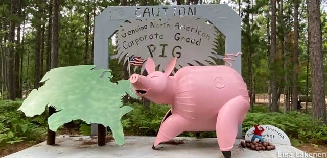 Corporate Greed Pig, doing something foul to the tiny American Worker.