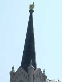 Church steeple with pointing hand.