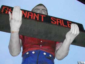 Muffler Man promotes the big rug remnant sale.