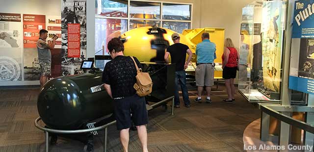 Visitors study replica historic bombs in the Bradbury Science Museum.