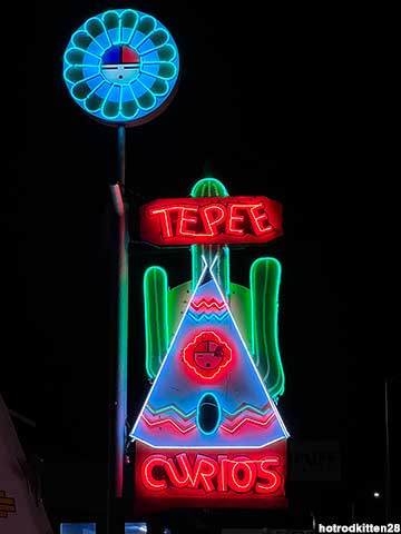 Tee Pee Curios sign at night.