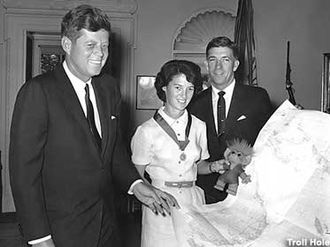 Betty Miller, record-setting pilot, introduces JFK to her lucky troll.