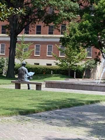 Statue reading a newspaper.