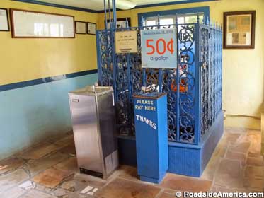 A cage protects the pump. Water fountain provides free samples.