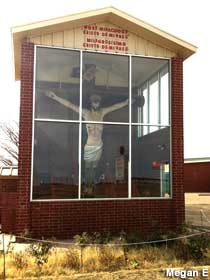 Christ crucified behind glass.