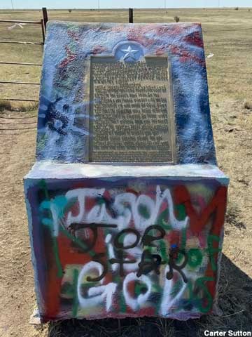 Plaque covered with graffiti.