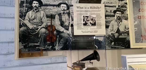 The Hammons Brothers pose with a fiddle, a rifle, and a 1903 Graphophone record player.