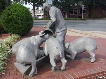 Man Slopping Pigs Statue.