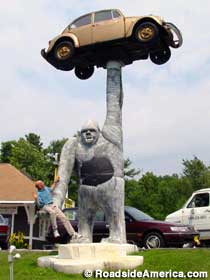 Gorilla holding up a VW Beetle.
